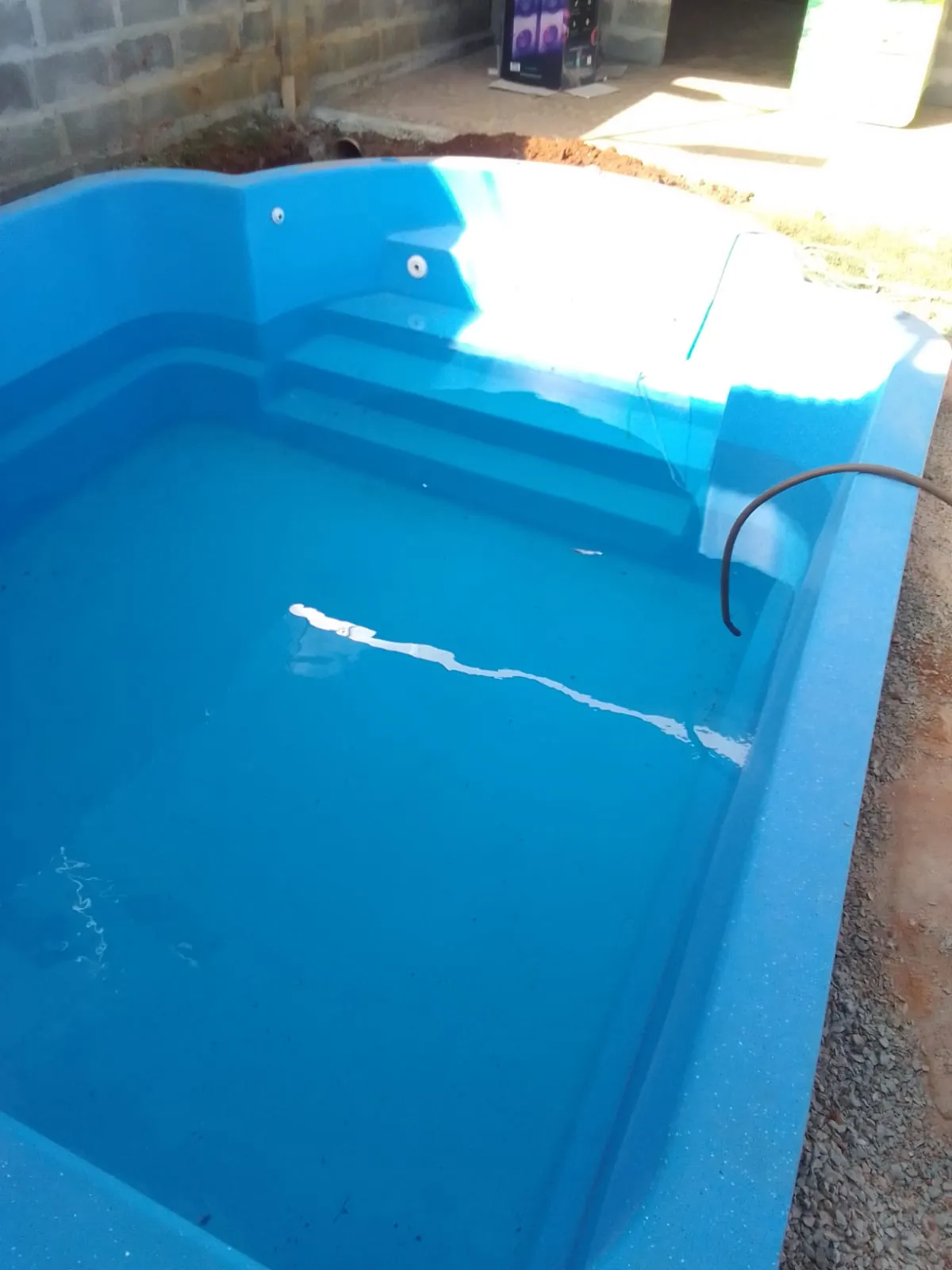 Piscina de fibra llenándose de agua durante la instalación