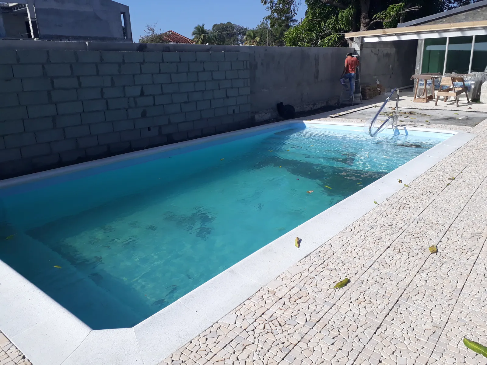 Piscina de fibra rectangular con borde blanco y deck de piedra