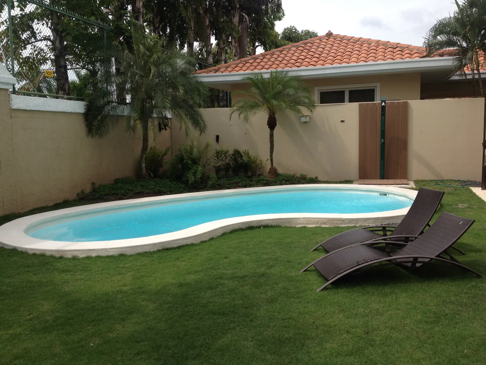 Piscina de fibra forma riñón en jardín