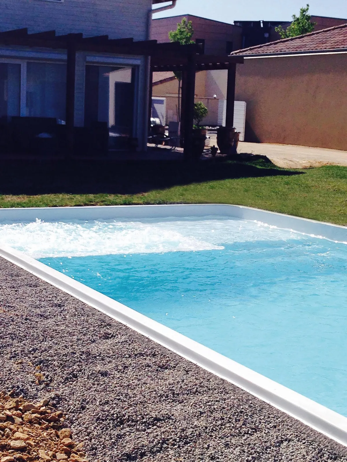 Piscina de fibra con borde blanco y grava