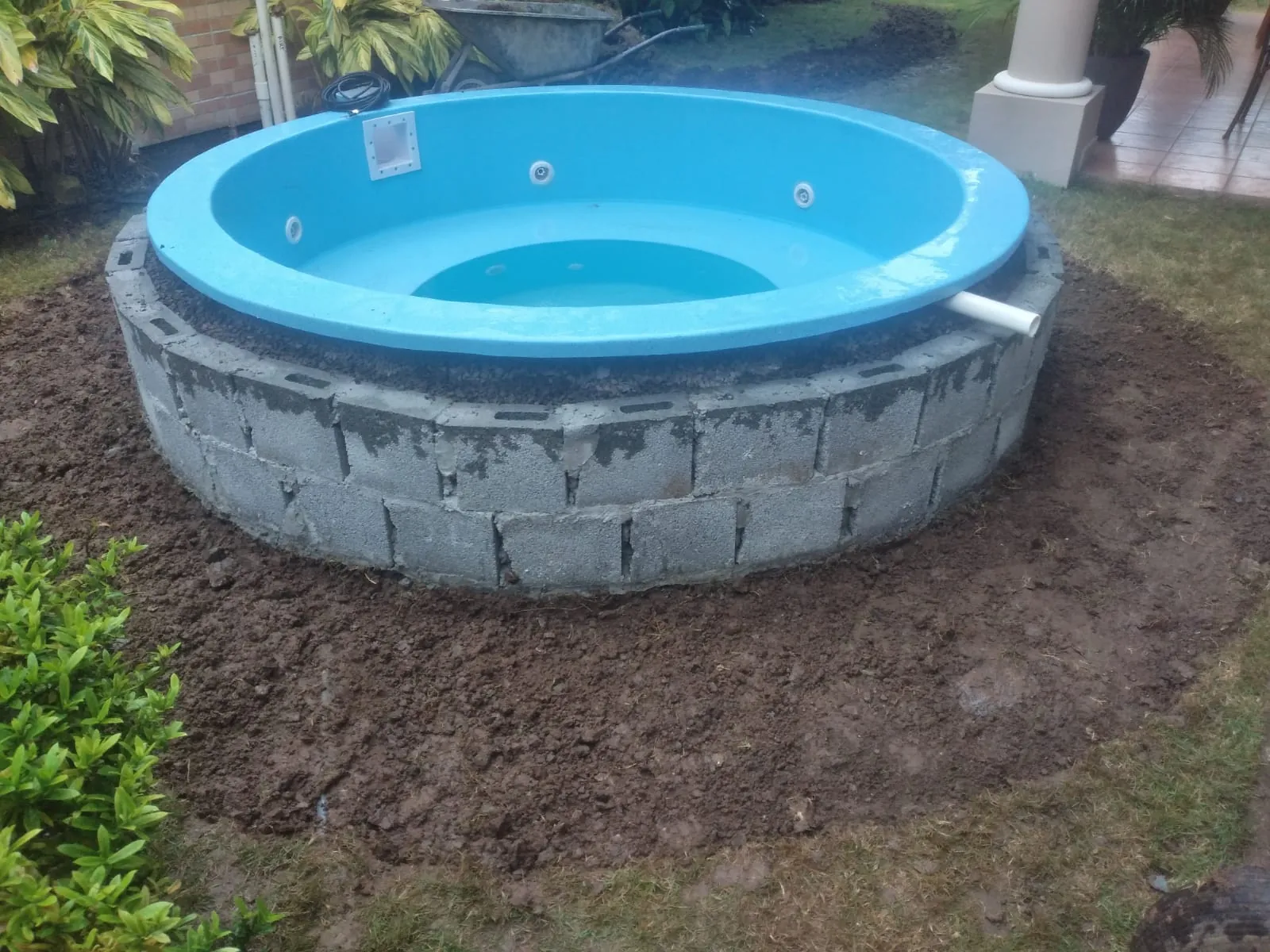 Instalación de jacuzzi redondo de fibra sobre base de bloques