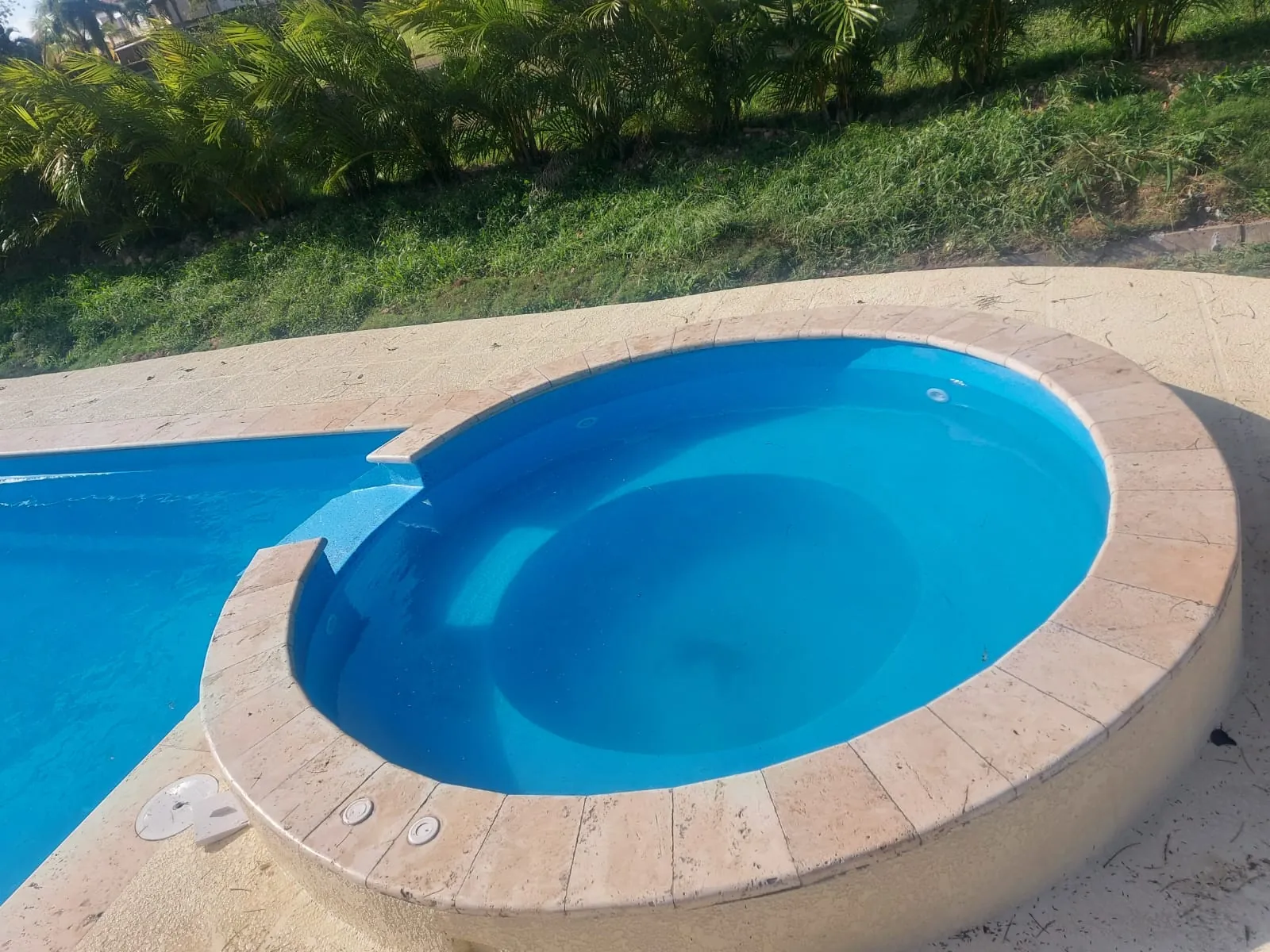 Jacuzzi redondo de fibra de vidrio junto a la piscina
