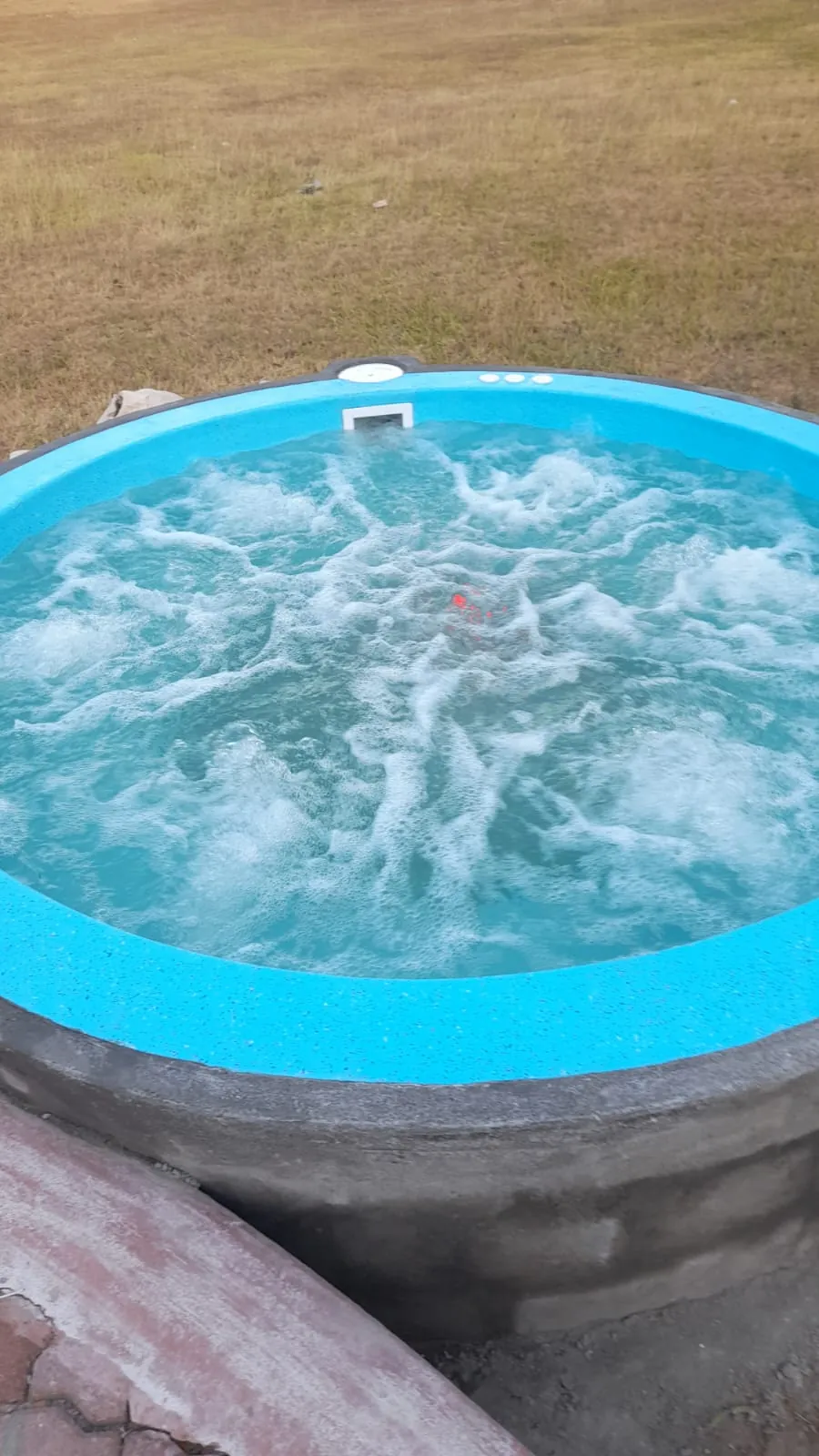 Jacuzzi redondo de fibra con chorros de hidromasaje encendidos