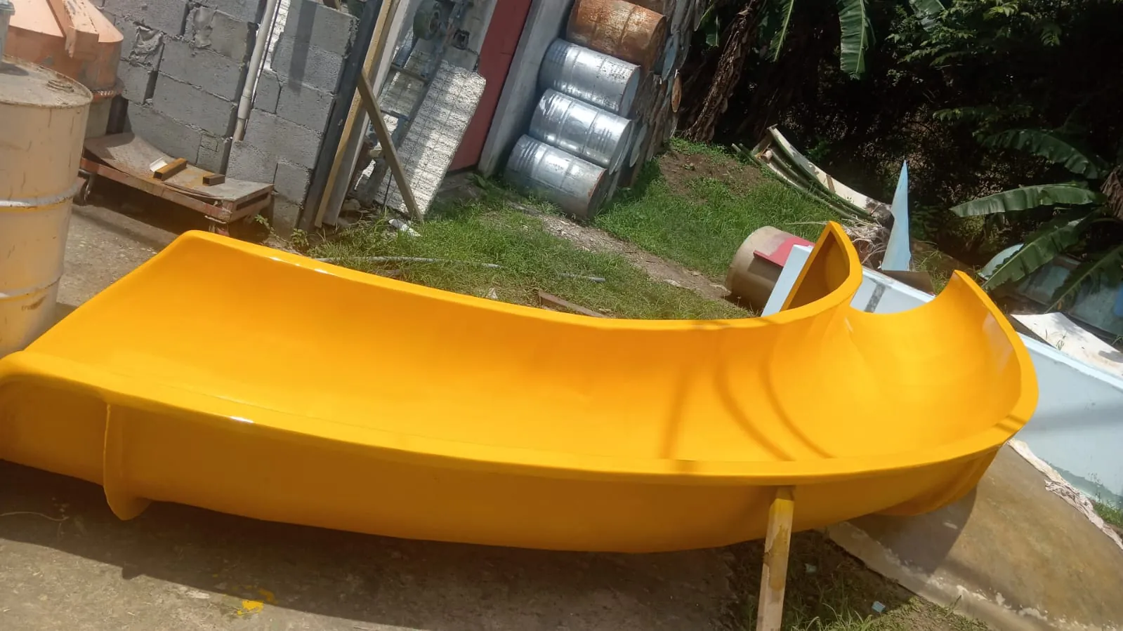 Tramo de tobogán de fibra de vidrio amarillo en la fábrica