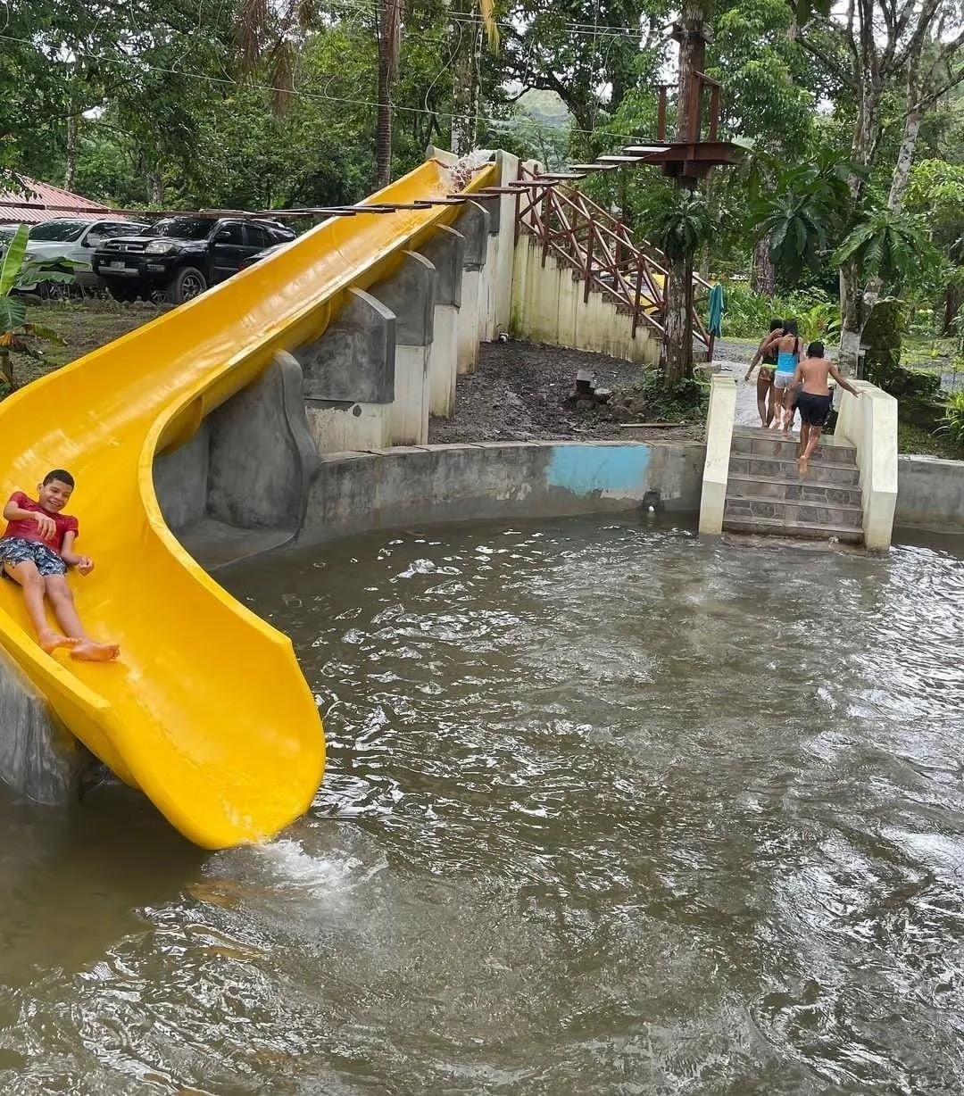 Tobogán de fibra de vidrio amarillo hacia un río