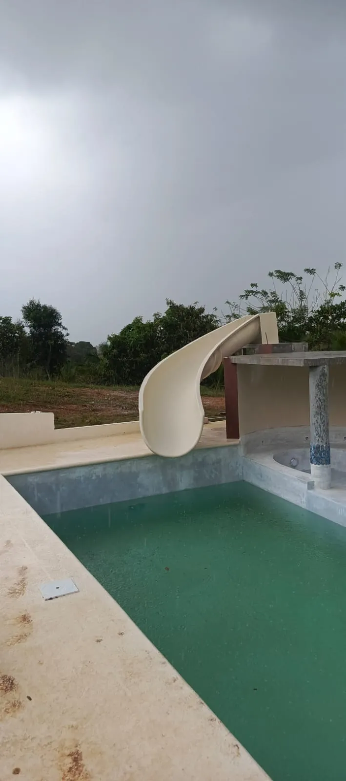 Tobogán de fibra beige curvo en piscina de concreto en Panamá